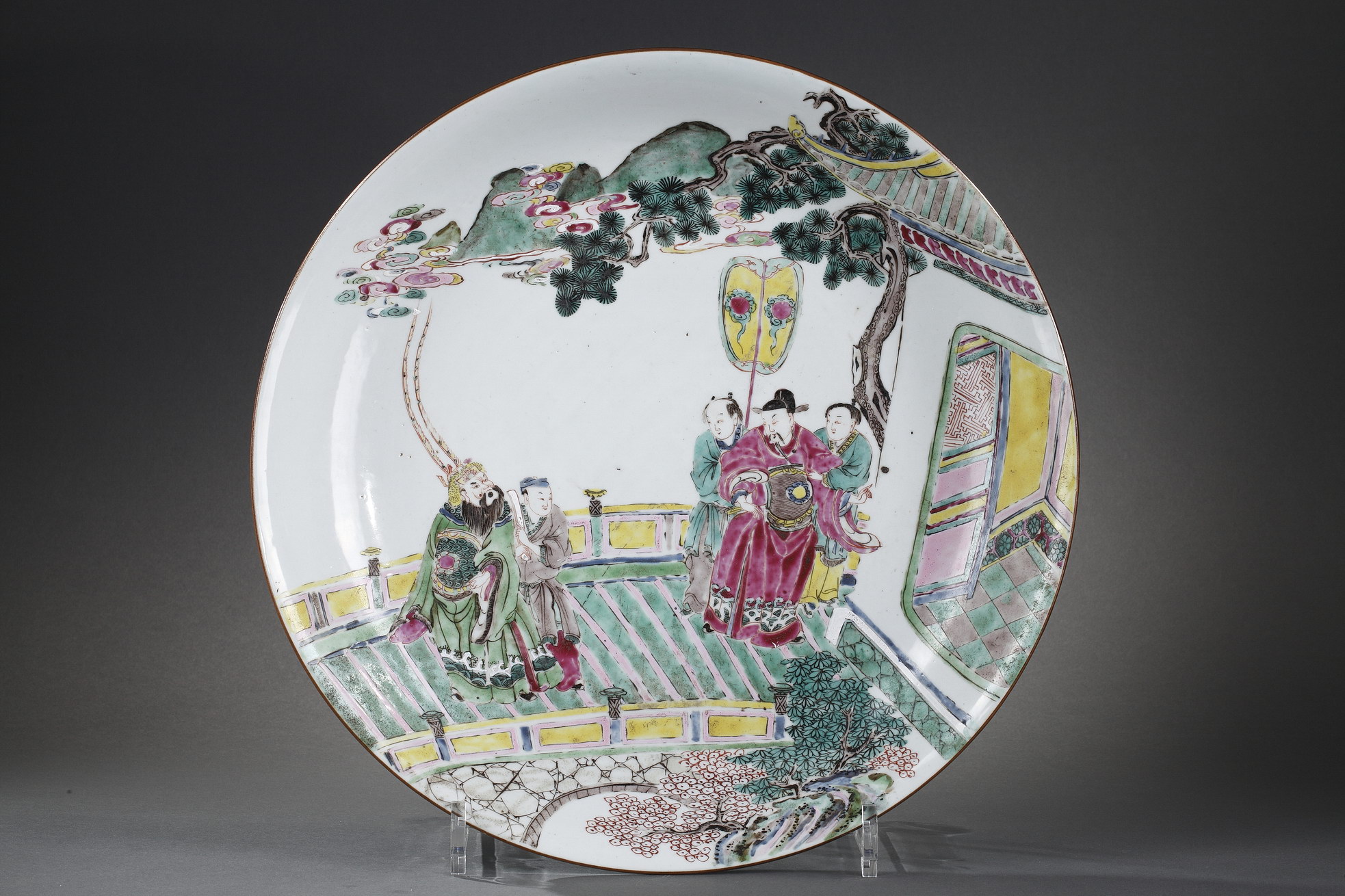 Plat en forme de coupe en porcelaine de la "famille rose" orné d'une célèbre scène de Roman représentant des personnages sur un pont devant un pavillon.