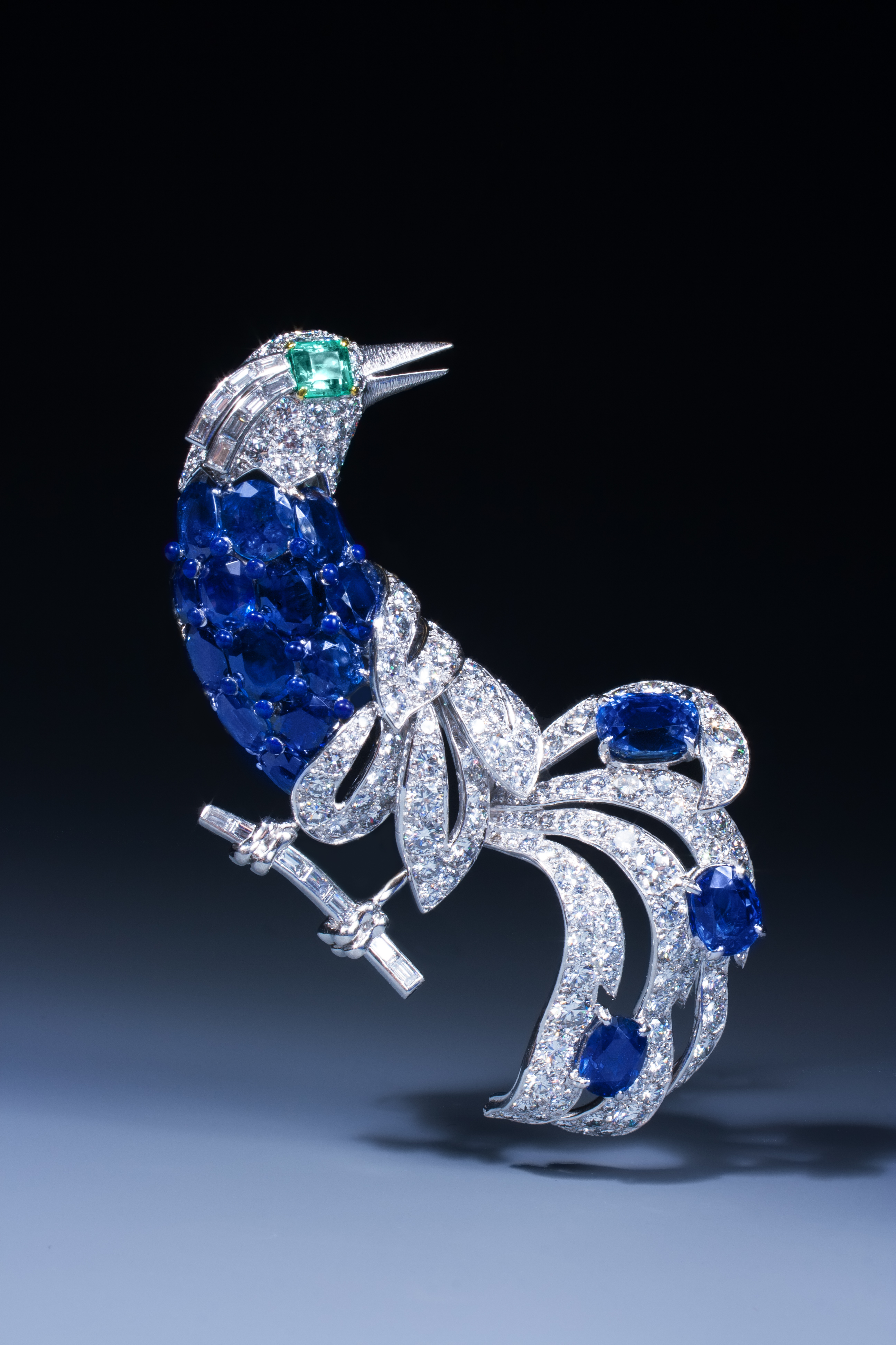 An important sapphire, emerald and diamond bird of paradise brooch by Cartier, mounted in platinum and gold.