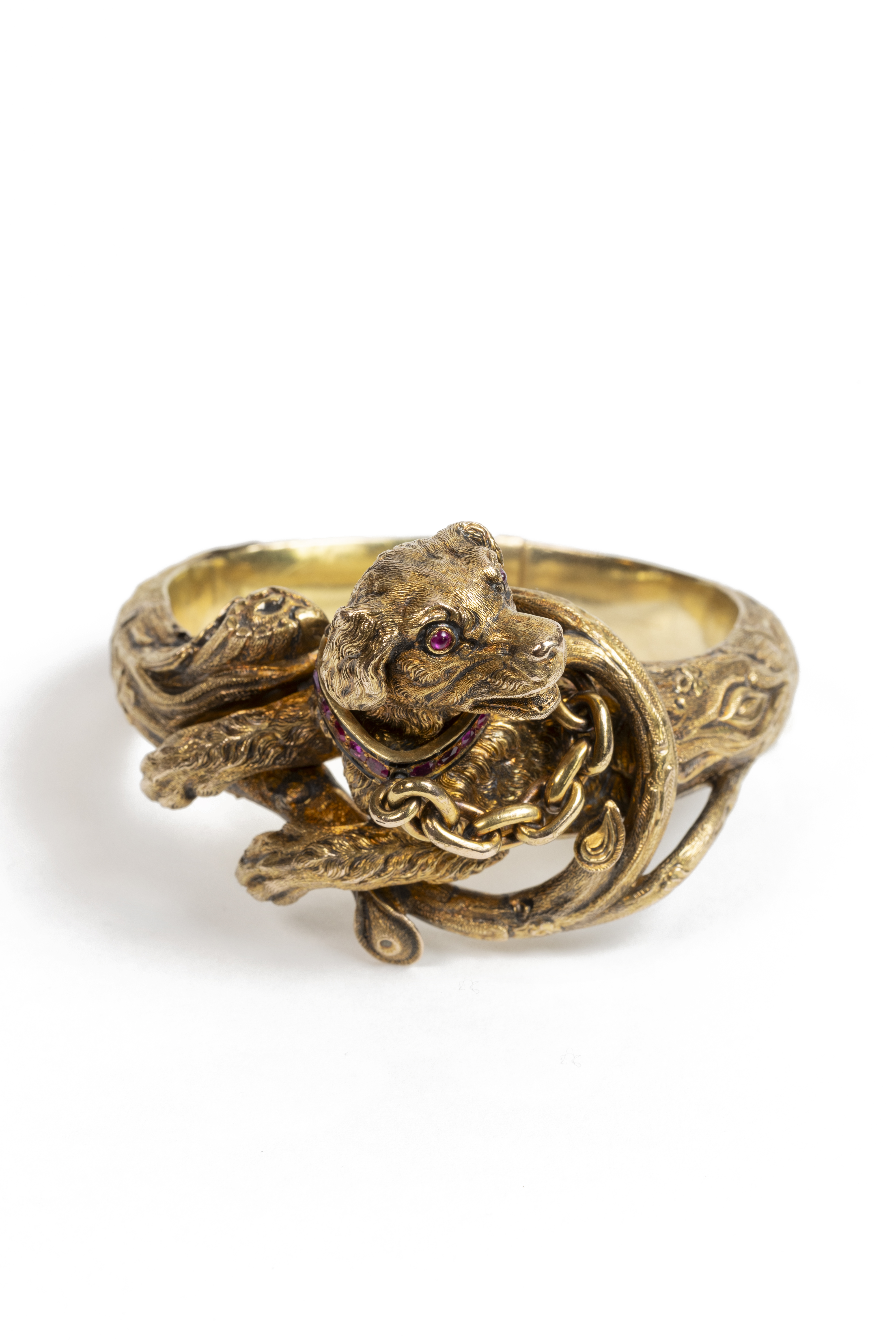 Bracelet chien, finement sculpté en or, les yeux et le collier sertis de rubis